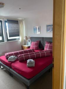 a bedroom with a large red bed with pink pillows at Bistro-zur-Quelle in Minden
