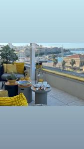 een balkon met tafels en uitzicht op de oceaan bij LA TERRAZZA SUL PORTO in Siracusa