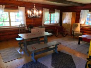 ein Wohnzimmer mit einem Tisch, Stühlen und Fenstern in der Unterkunft Kotka Farm in Saareküla