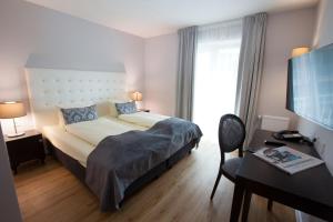 فندق راينيشير هوف باد سودين في باد سودن آم تاونوس: غرفة في الفندق بها سرير ومكتب ومكتب