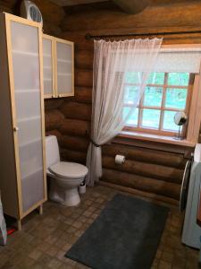 a bathroom with a toilet and a window at Kotka Farm in Saareküla