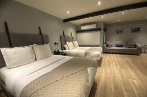 a hotel room with two beds and a couch at Hotel Verbena in San Miguel de Allende