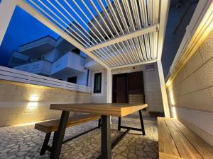 a wooden bench sitting in the middle of a patio at OWNER ITALY - APARTMENT B in Torre San Giovanni Ugento +42 photos