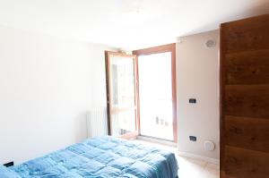 um quarto com uma cama e uma grande janela em la maison jaune em Aosta