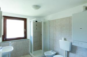 uma casa de banho com um lavatório, um WC e um chuveiro em la maison jaune em Aosta