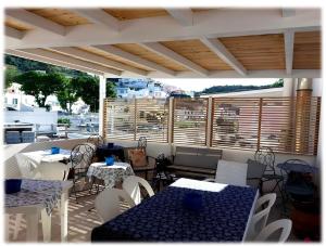 a patio with tables and chairs and windows at La casa dei 4 venti Affittacamere in Ponza