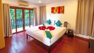 White Flower Lanta في كو لانتا: غرفة نوم مع سرير مع دمية دب عليها