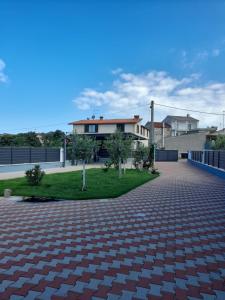 a brick driveway with a house in the background at Apartments Donella in Umag