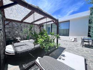 een patio met een bank en een aantal stoelen bij One Bedroom Pool House by Olivujoj in Anavissos