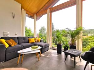 a living room with a couch and a table at DAS Ferienhaus Waldblick in Güntersberge