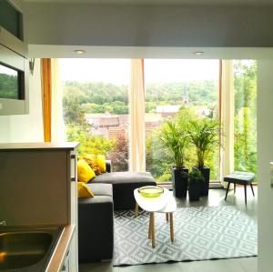 a living room with a couch and a large window at DAS Ferienhaus Waldblick in Güntersberge