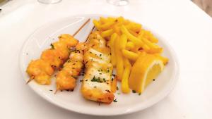 un plato de comida con camarones y papas fritas en Hotel Queen Mary, en Cattolica