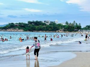 a woman and a child standing on a beach at Scenia Bay Residence Nha Trang in Nha Trang