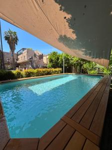 - une grande piscine avec un banc en bois à côté dans l'établissement Ancient Luxury Home with heated pool near Catania, Taormina, the Sea and Mount Etna, à Giarre