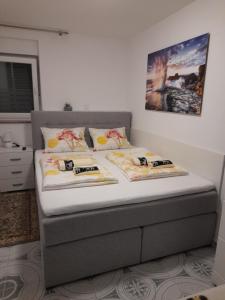 a bed in a bedroom with two pillows on it at Apartments Donella in Umag