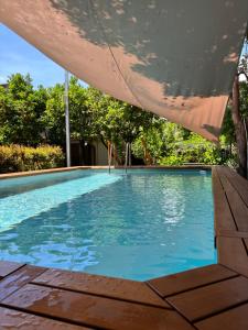 a large swimming pool with a umbrella over it at Luxury Historic Villa with heated pool near Catania, Taormina, the Sea and Mount Etna by SicilianRelaxingHomes in Giarre