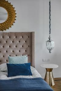 a bedroom with a blue bed with a mirror at Prawdzic Family Resort & Wellness in Gdańsk