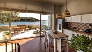 a kitchen with a table and a view of the water at Casa Mano Tribunj with beach in Tribunj