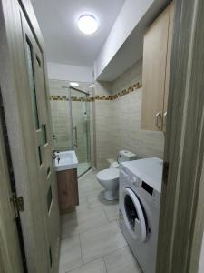 uma casa de banho com um WC e uma máquina de lavar roupa em Angi House Otopeni em Otopeni