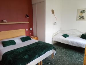1 Schlafzimmer mit 2 Betten und grüner und weißer Bettwäsche in der Unterkunft GITE LA NOTARIALE 