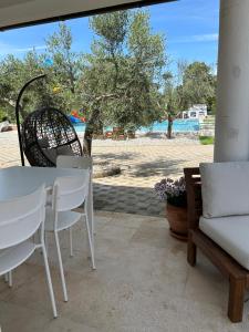 patio ze stołem i krzesłami oraz plażą w obiekcie VOLMEness w Puli