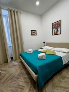 1 dormitorio con 1 cama grande con manta azul en Dimora Dei Decumani, en Nápoles