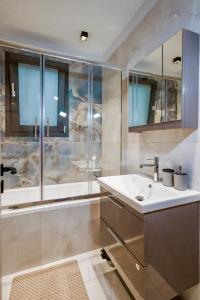 W łazience znajduje się wanna, umywalka i prysznic. w obiekcie Urban Apartments w Chios
