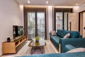 uma sala de estar com um sofá azul e uma mesa em Urban Apartments em Quios