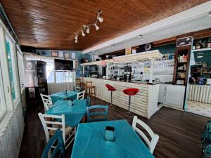 a restaurant with blue tables and chairs and a counter at Elba Travels in Capoliveri