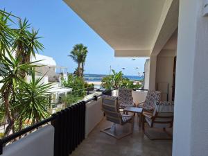 a balcony with a table and chairs and the beach at Villa 2M a 50 metri dal mare in San Vito lo Capo