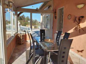 a dining room with a glass table and chairs at La petite colline du Cros, villa à louer in Saint-Pierre-de-Chignac