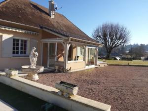 a house with a fountain in front of a yard at La petite colline du Cros, villa à louer in Saint-Pierre-de-Chignac