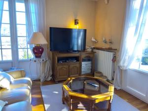 a living room with a tv and a coffee table at La petite colline du Cros, villa à louer in Saint-Pierre-de-Chignac