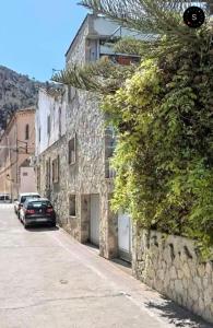 un coche aparcado en una calle al lado de un edificio de piedra en Lo Jardí de Benifallet en Benifallet
