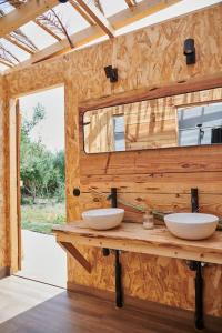 uma casa de banho com 2 lavatórios numa parede de madeira em Tranquilo Glamping em Hozanejos