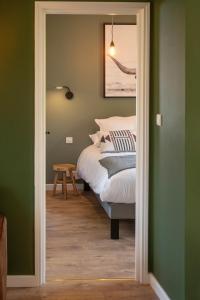 a bedroom with green walls and a bed at Hôtel Restaurant Le Fiacre à Quend plage in Quend