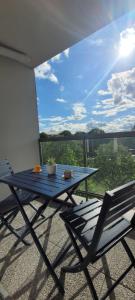 a blue table and chair on a balcony with a view at Cozy apartment at Paris doors with free car-park in Saint-Denis