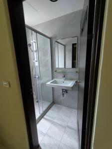 y baño con lavabo, ducha y espejo. en Carlos Backpacker en Minxiong