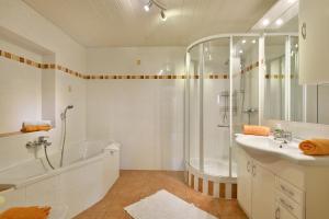 a bathroom with a shower and a sink and a tub at Haus Sonnenschein in Thiersee