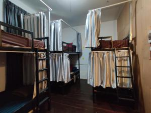 a room with three bunk beds and curtains at Via Hostel Pakse in Pakse