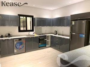 a kitchen with stainless steel appliances and gray cabinets at Kease Ghadeer A-4 Royal touch Terrace XZ99 in Riyadh