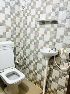 a bathroom with a toilet and a sink at Mauji's Villa Hotel & Guest House in Prayagraj