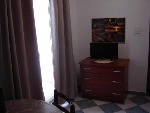ein Schlafzimmer mit einer Kommode mit einem Fernseher drauf in der Unterkunft Apartmani Sobe KATICA in Cres