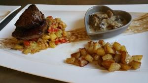 a plate with meat and potatoes and a bowl of food at Le 49 Côté Parc & SPA in Domblans