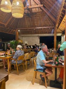 a group of people sitting at tables in a restaurant at Abian Ayu Villa in Sidemen