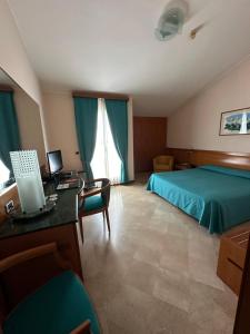 1 dormitorio con 1 cama y escritorio con ordenador en Hotel Vecchio Mulino, en Monopoli