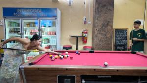 a woman playing pool on a pool table at Lucky Buako Hotel Patong in Patong Beach