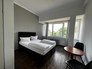 1 dormitorio con cama, mesa y ventana en Ootel.com en Berlín