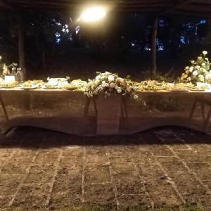Locanda Rosati في أورفييتو: طاولة عليها طعام وزهور في الليل