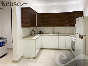 uma cozinha com electrodomésticos brancos e armários de madeira em Kease Hittin B-5 Elegance AG32 em Riyadh